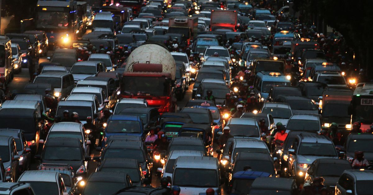 a an 8-lane highway with every lane filled with cars, trucks, and motorcycles going between lanes