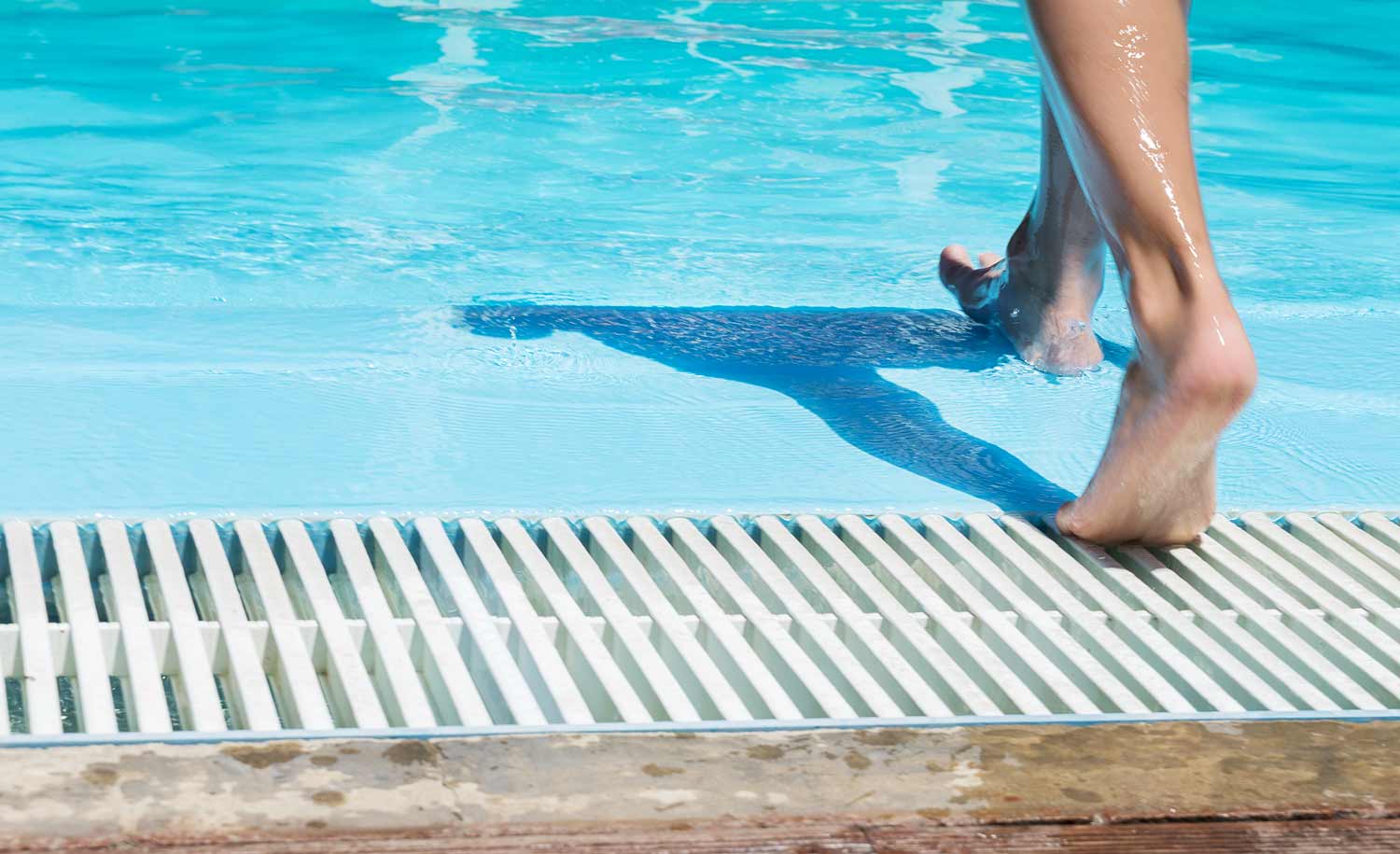 Person walking into a swimming pool
