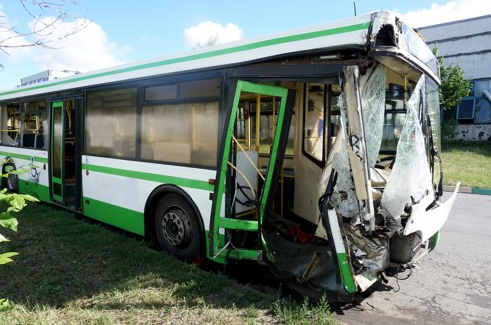 crashed city bus on side of road