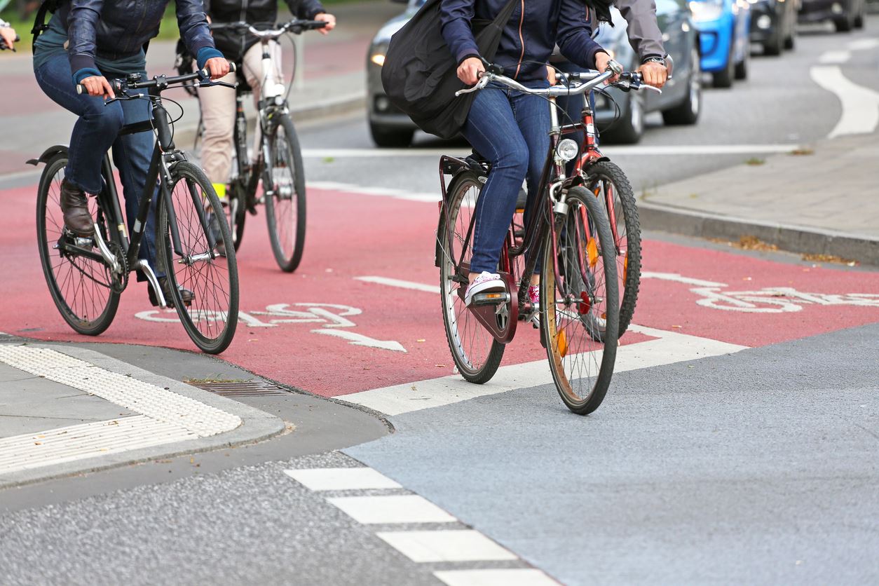 Friends in jackets on bicycles crossing the street