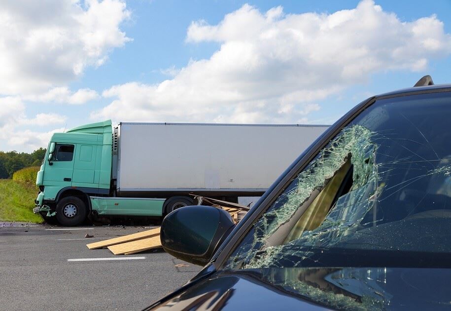 badly damaged car after truck accident